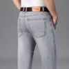 Jean homme, coupe droite, en coton stretch, gris clair, taille haute, style business décontracté.
