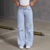 Jean boyfriend déchiré pour femme, coupe droite, jambes larges, en denim stretch avec trous, poches et taille haute confortable.