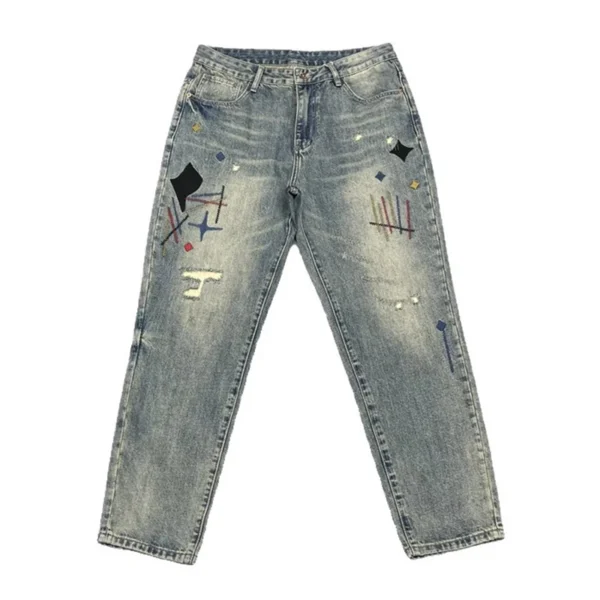 Jean homme tendance, audacieux et élégant, orné de broderies et d'imprimés patchwork, coupe droite ample.
